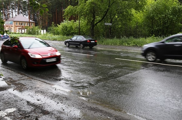 Между двумя знаками, обозначающими въезд в город Берёзовский на гостевом маршруте, автомобилистов встречает разбитый участок трассы