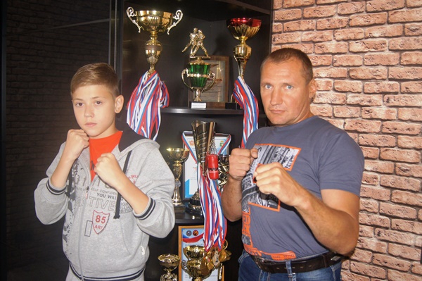  Федор Джулай и его тренер Дмитрий Стенин. На заднем плане – награды юного спортсмена