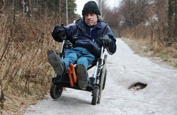 Инвалид-колясочник Владимир Шадымов на тротуаре возле профилактория по ул. Шиловской. Здесь он  с большой осторожностью преодолевает яму, появившуюся несколько лет назад